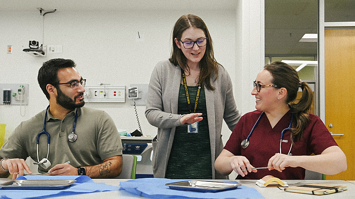 Graduate students engaged in hands-on clinical learning with faculty support.