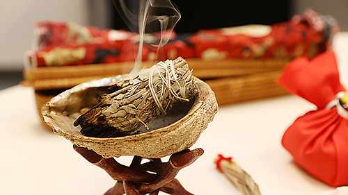 A close-up photo of a smudge bowl and white sage